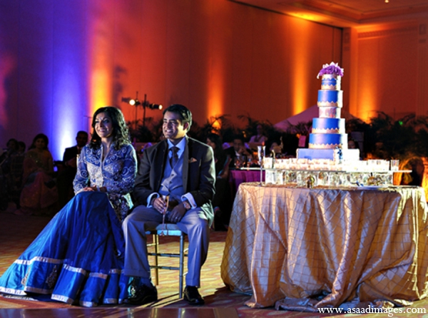The bride and groom wait to cut the cake at the reception.