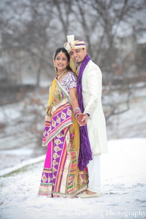 A portrait of the Indian wedding couple in their traditional wedding dress.