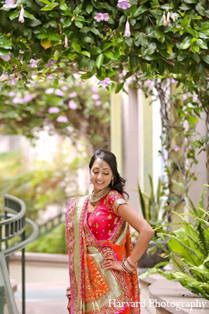 This stylish bride and groom celebrate their wedding festivities in Santa Monica, California. They choose bright pink and orange for their ceremony and a softer palette for their reception.