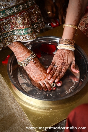 An Indian bride and groom wed in a traditional Hindu ceremony. They choose a classic theme of ivory, red, and gold for their wedding and a soft green and violet theme for their reception.