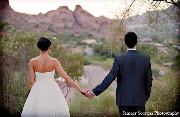 An Indian bride and groom wed in outdoor ceremony in Arizona. They choose a traditional Indian theme for their wedding while opting for a more modern approach to their reception in a white dress and tuxedo.