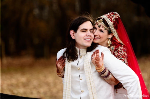 A portrait of the bride and groom on their wedding day. They are wearing traditional ceremonial dress. The bride in a lengha and the groom in a sherwani.