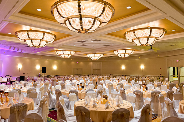 Indian wedding vendors decorate this ballroom in a modern style.
