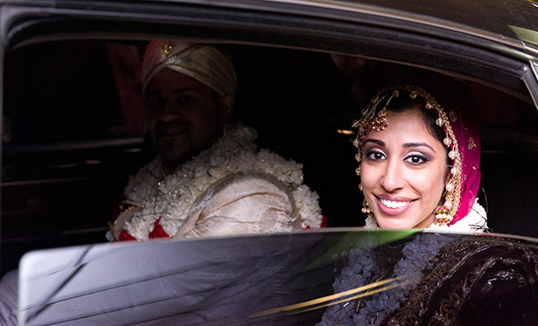 An Indian bride and groom depart their Indian wedding venue.