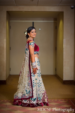 Indian bride in indian bridal jewelry matching her wedding lengha.