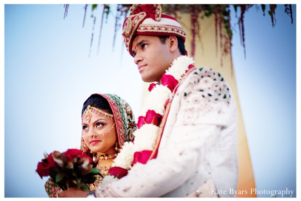 An Indian bride and her groom in traditional indian wedding outfits.