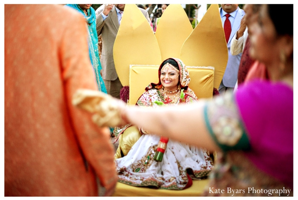 An Indian bride arrives on a yellow palanquin to her indian wedding.