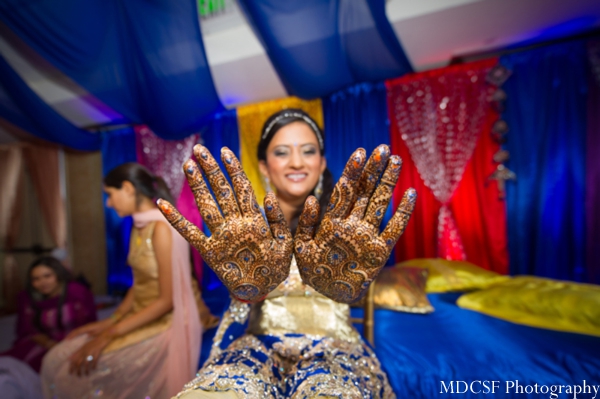 Bridal mehndi on hands with touches of blue.