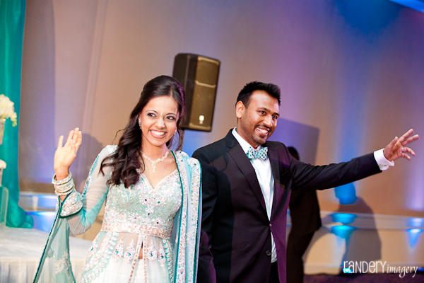 An indian bride and groom waves to family and friends at the Indian wedding reception.