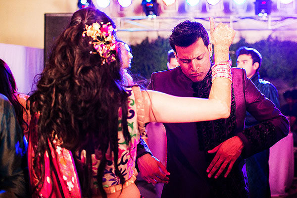 An Indian bride and groom dance at the outdoor sangeet in Udaipur, India.