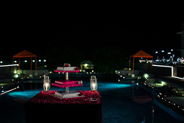 An Indian wedding cake overlooks this outdoor Indian wedding reception.