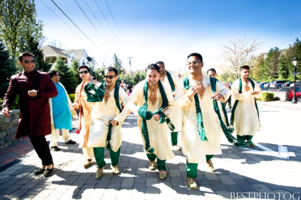 Indian groomsmen in traditional Indian wedding outfits dance to the ceremony.