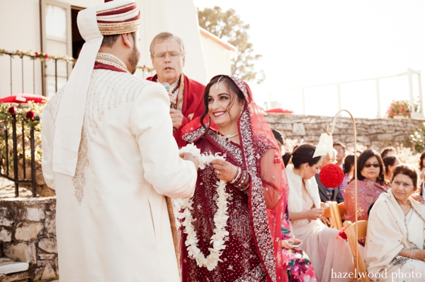 An Indian bride puts a jaimala flower garland on her groom.