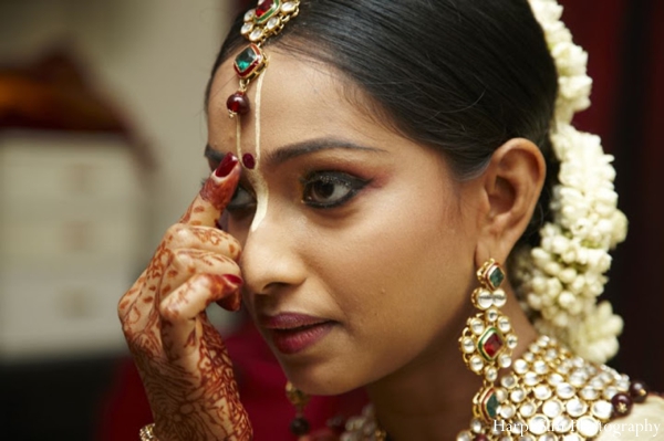 Indian bride receives turmeric to her face during her Indian wedding ceremony.