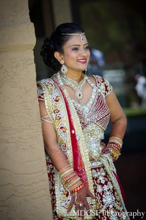 Indian bride poses in traditional bridal lengha.