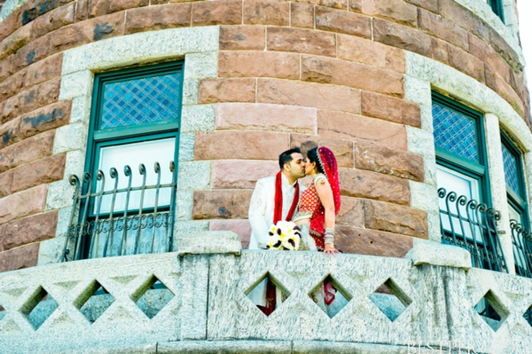 An Indian bride and groom kiss in this Indian wedding portrait.