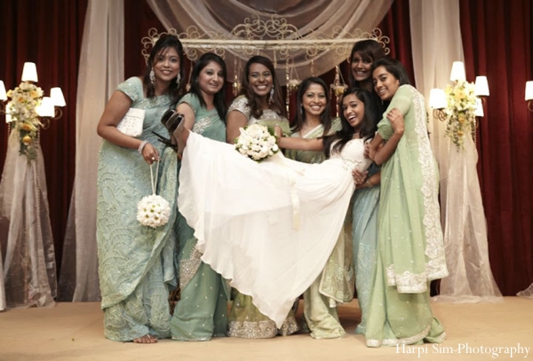 Indian bride wears white gown while indian bridesmaids wear green bridal sari fashion.
