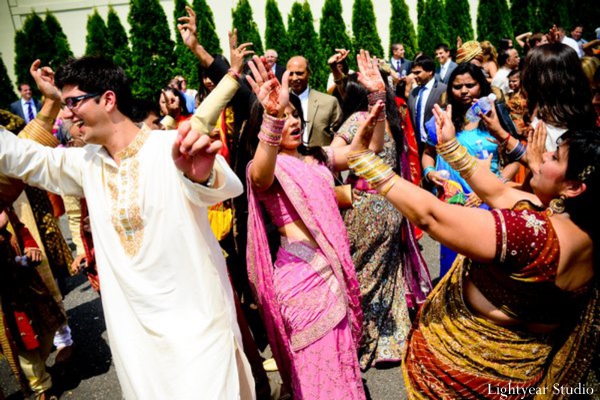 Indian wedding baraat with dancing friends and families.