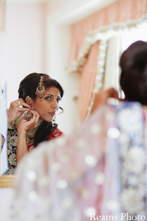 indian bride puts on indian wedding jewelry.