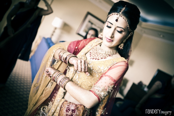 Indian bride puts on traditional indian wedding dress.
