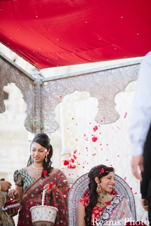 Indian bride has petals thrown at her in indian wedding tradition.