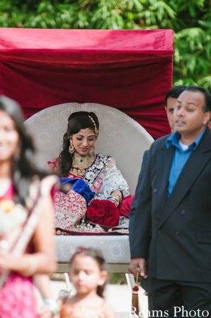 Indian bride rides in palanquin to indian wedding ceremony.