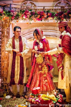 indian wedding bride and groom under mandap.