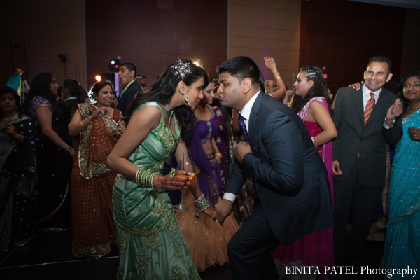Indian bride and groom dance at indian wedding reception.