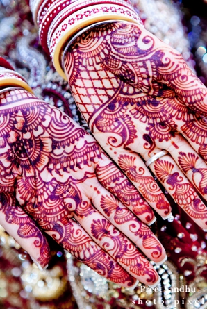 indian bride wears bridal mehndi on her hands.