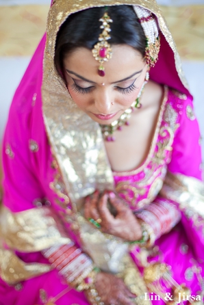 indian bride wears pink bridal outfit to sikh wedding ceremony.