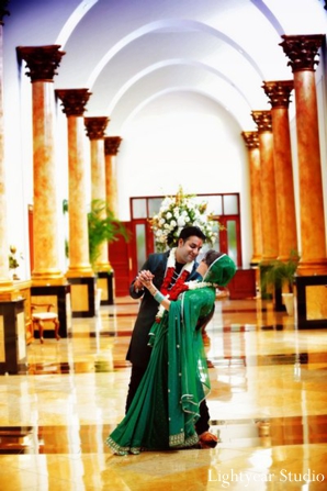 Indian bride wears modern green bridal sari fashion.