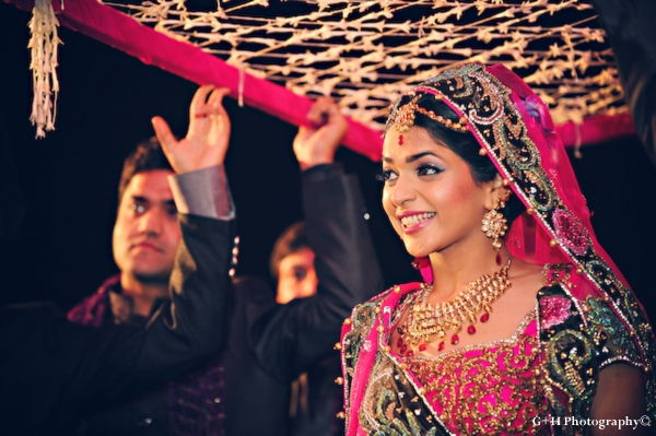 Indian bride enters indian wedding ceremony in hot pink wedding lengha