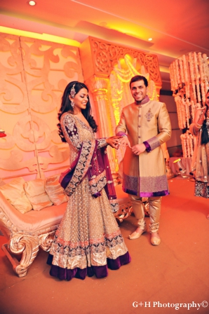 Indian bride wears gold and purple wedding outfit for engagement party