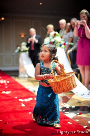 Indian wedding flower girl walks the aisle.