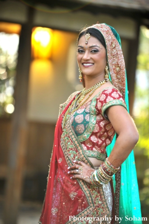 Indian bride in red, white and green wedding lengha.