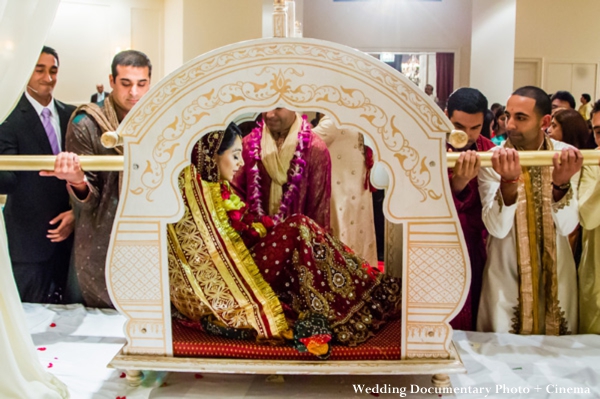Indian bride arrives to indian wedding ceremony in a palanquin.