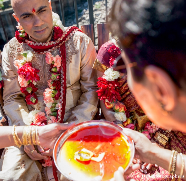 Indian groom wearing traditional sherwani and jaimala flower garlands.