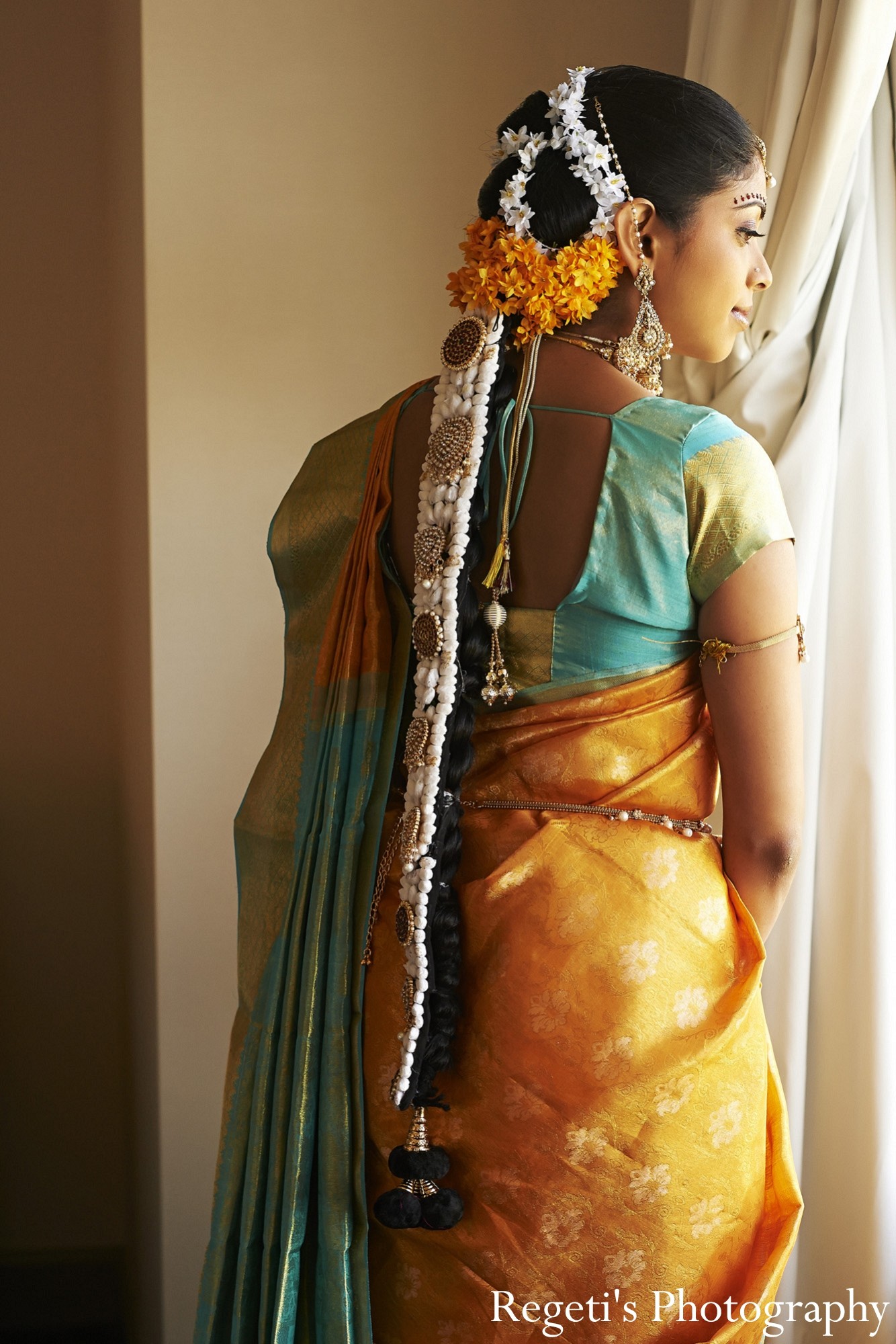KnotsbyAmp - Tying the Pudavai (saree), doing the traditional bridal hair  with Souri and Naga Jadai , adorning the forehead with Nethi Chuti  (maang-tika) and tying the Odiyanam (belt in the centre)