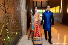 An Indian bride and groom celebrate at their colorful sangeet.