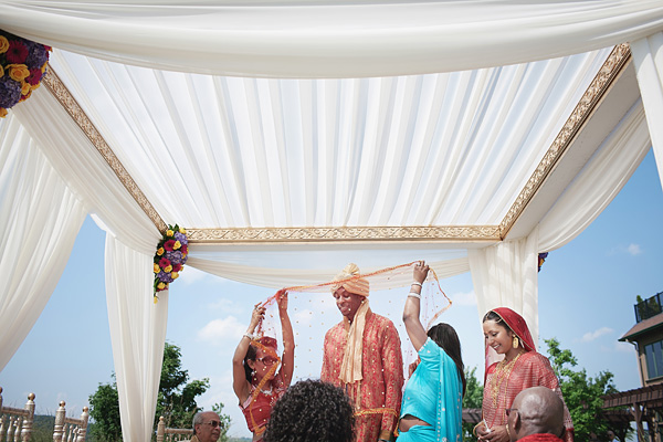 An outdoor Indian wedding under a white mandap.