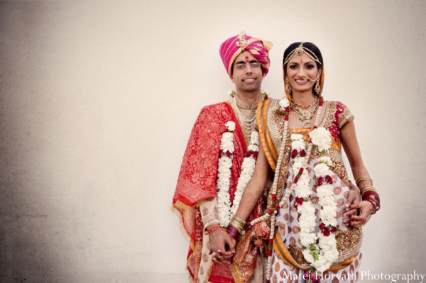 An Indian bride and groom in traditional Indian wedding outfits.