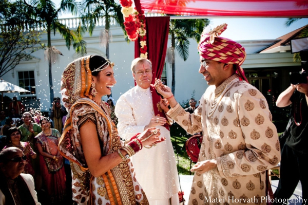 An Indian bride wears a white and gold bridal lengha at her ceremony.